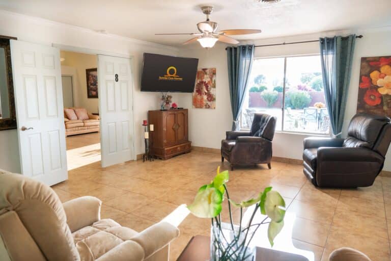 A living room with a large window, tv, and couches.