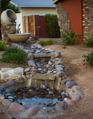 A small garden with fountain and rocks.